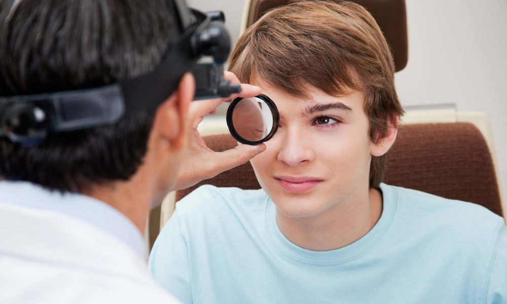 Optometrist taking a closer look at pupil while performing dilated retinal exam